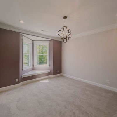 A Two-Wall View Of A Well-Painted Room, With An Accent Wall Painted In A Dark Shade Of Beige And Others In A Lighter Shade