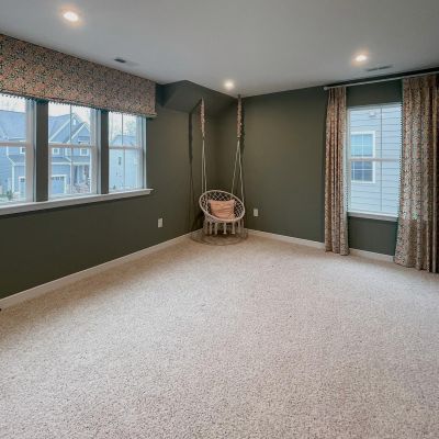 A Drawing Room With Hunter-Green Color Walls, Ceiling Painted In White, And A Few Slider Windows With Curtains