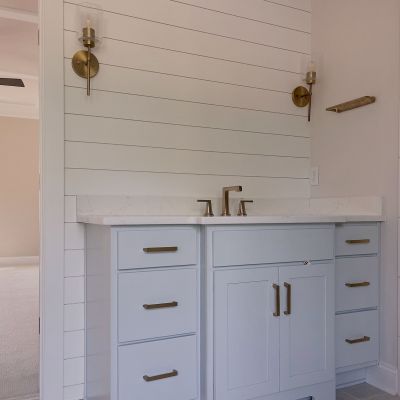 Corner Inside A House With A White-Painted Wooden Vanity Unit And A Wall With Textured Paint In A Pastel Color