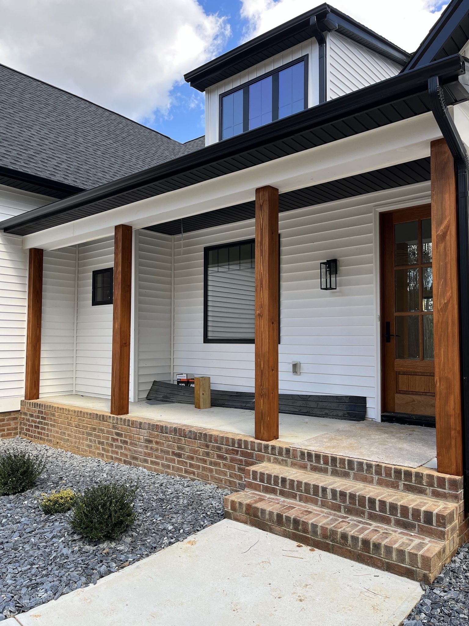 Front Porch With Stained Wood Posts And White Siding