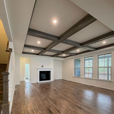 Main Hall Of The House With White Painted Walls Lush Brown Marble Flooring, And Three Slider Windows On The Right