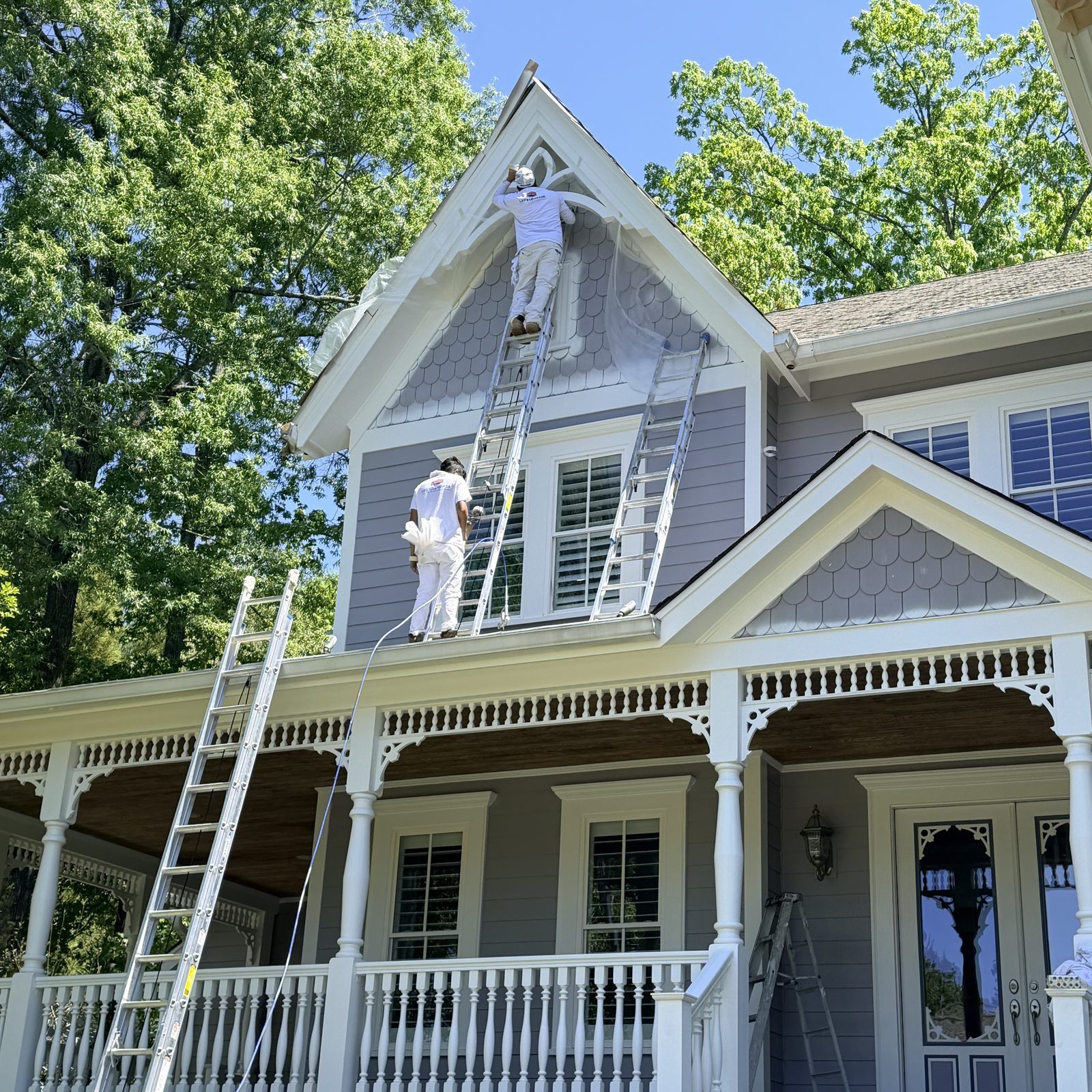 Painters On Ladders Painting A Farmhouse With A Front Porch