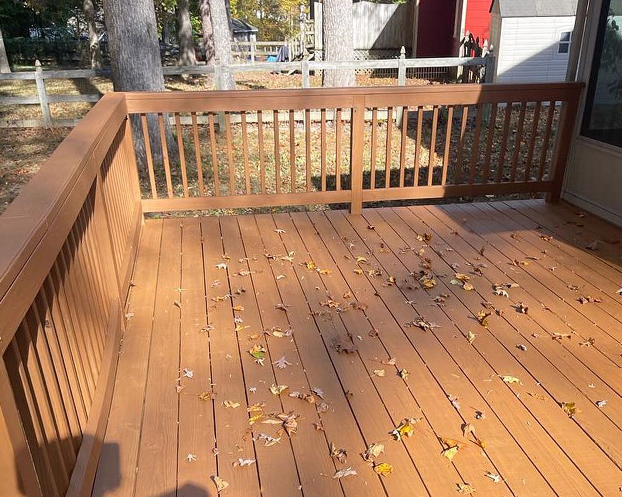 After Photo Of Recently Stained Deck Boards In The Sun With Leaves