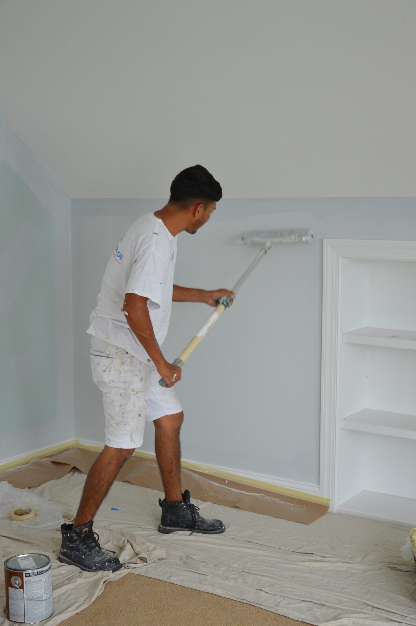 Painter Rolling A Light Blue Wall