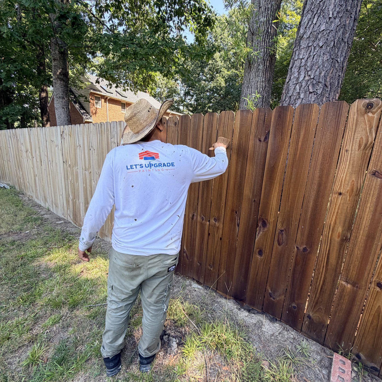 Wood Privacy Fence Half Stained By A Painter
