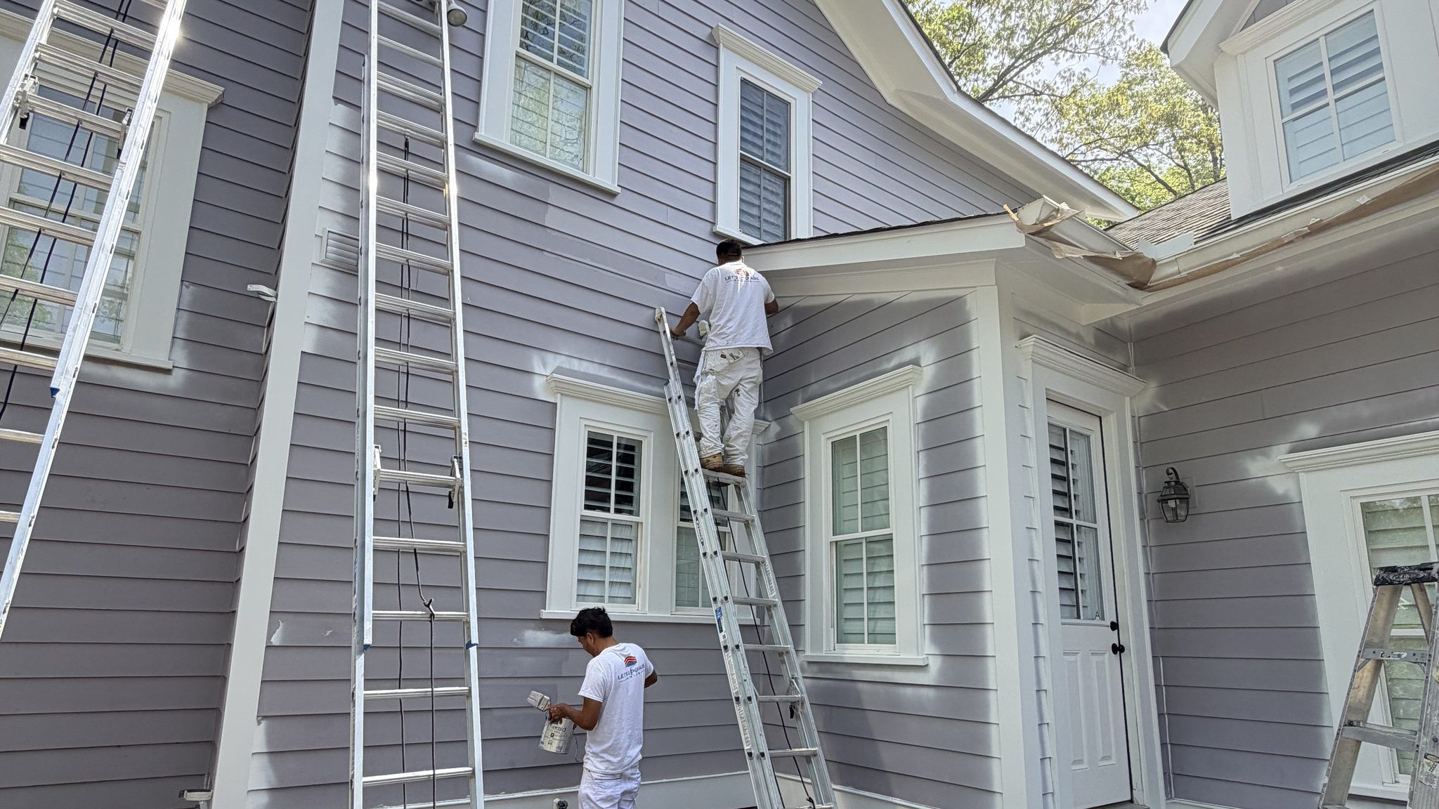 Painters On Ladders Painting A Lavender Siding Home