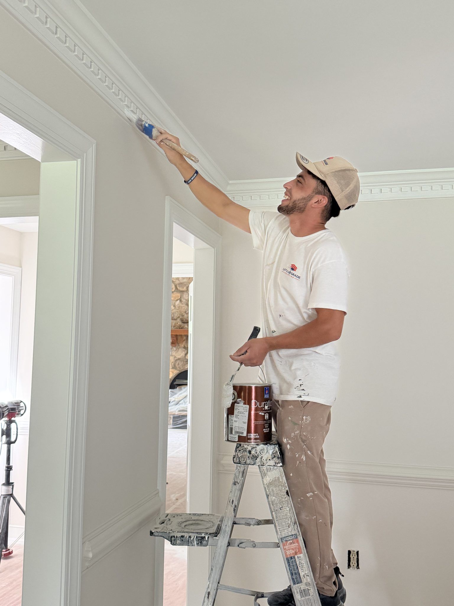 Painter On A Ladder Painting Crown Molding