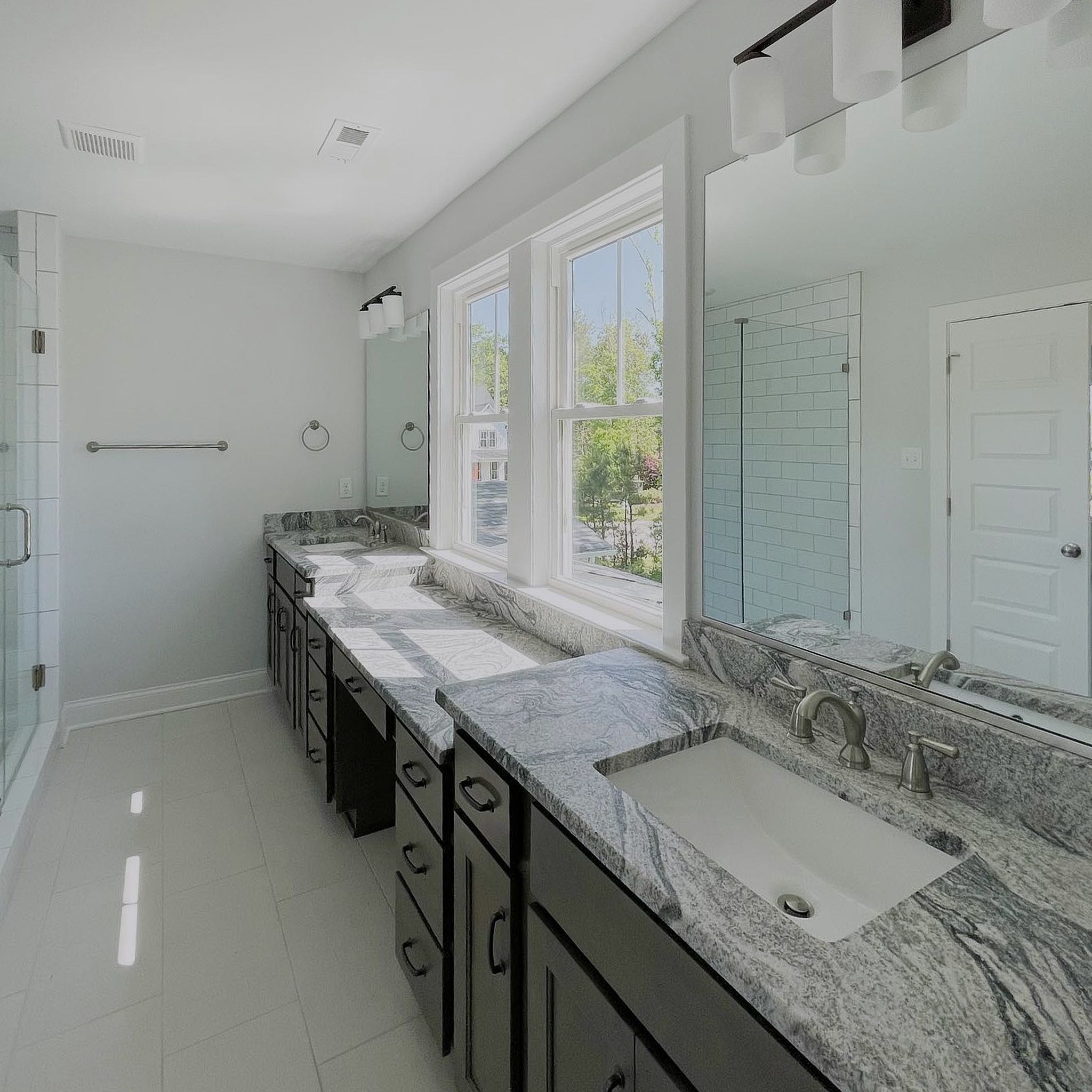 Side View Of A Cleanly Painted White Dressing Area With Two Wash Basis And Slider Windows For Daylight