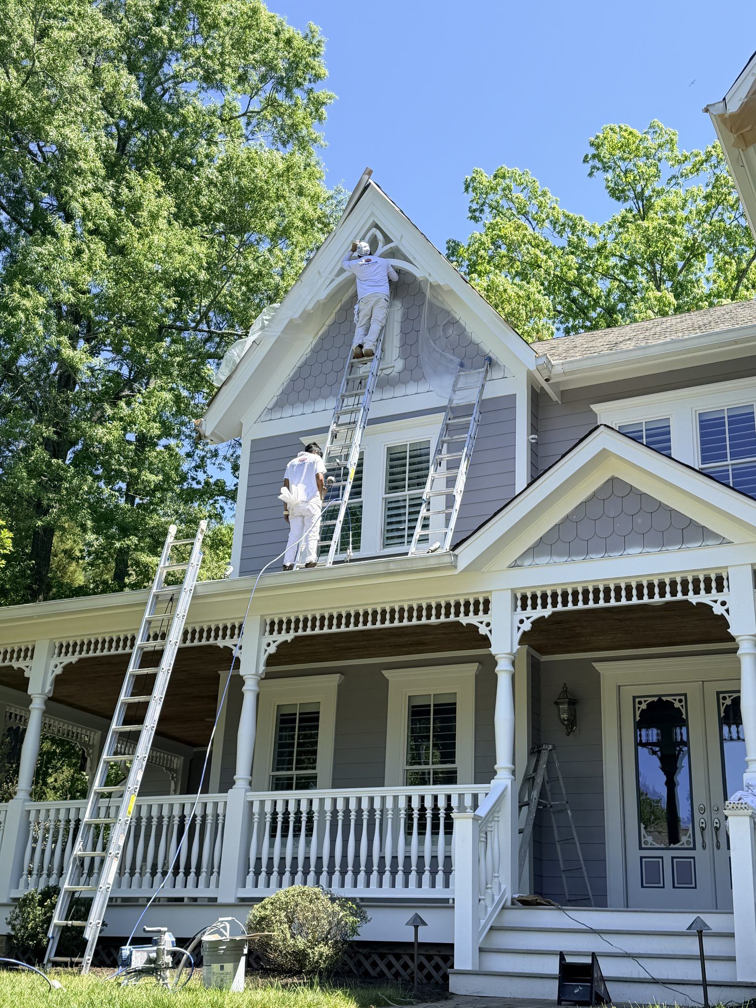 Painters On Ladders Painting A Farmhouse With A Front Porch