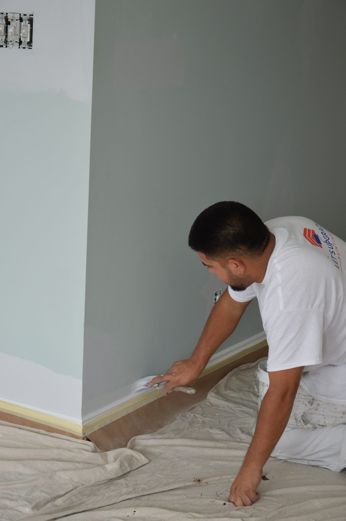 Painter Cutting In Along A Baseboard