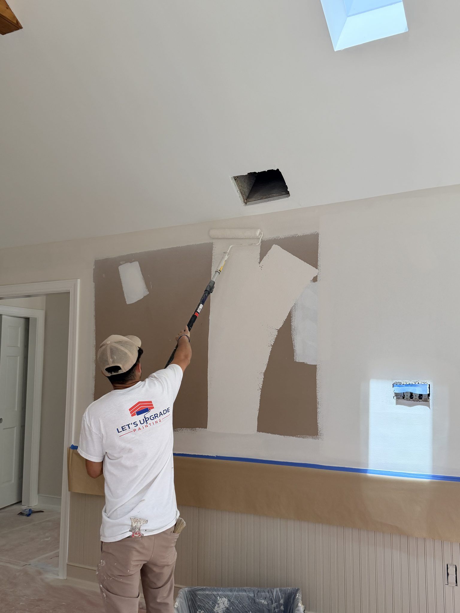 Painter Priming Patched Walls With A Roller
