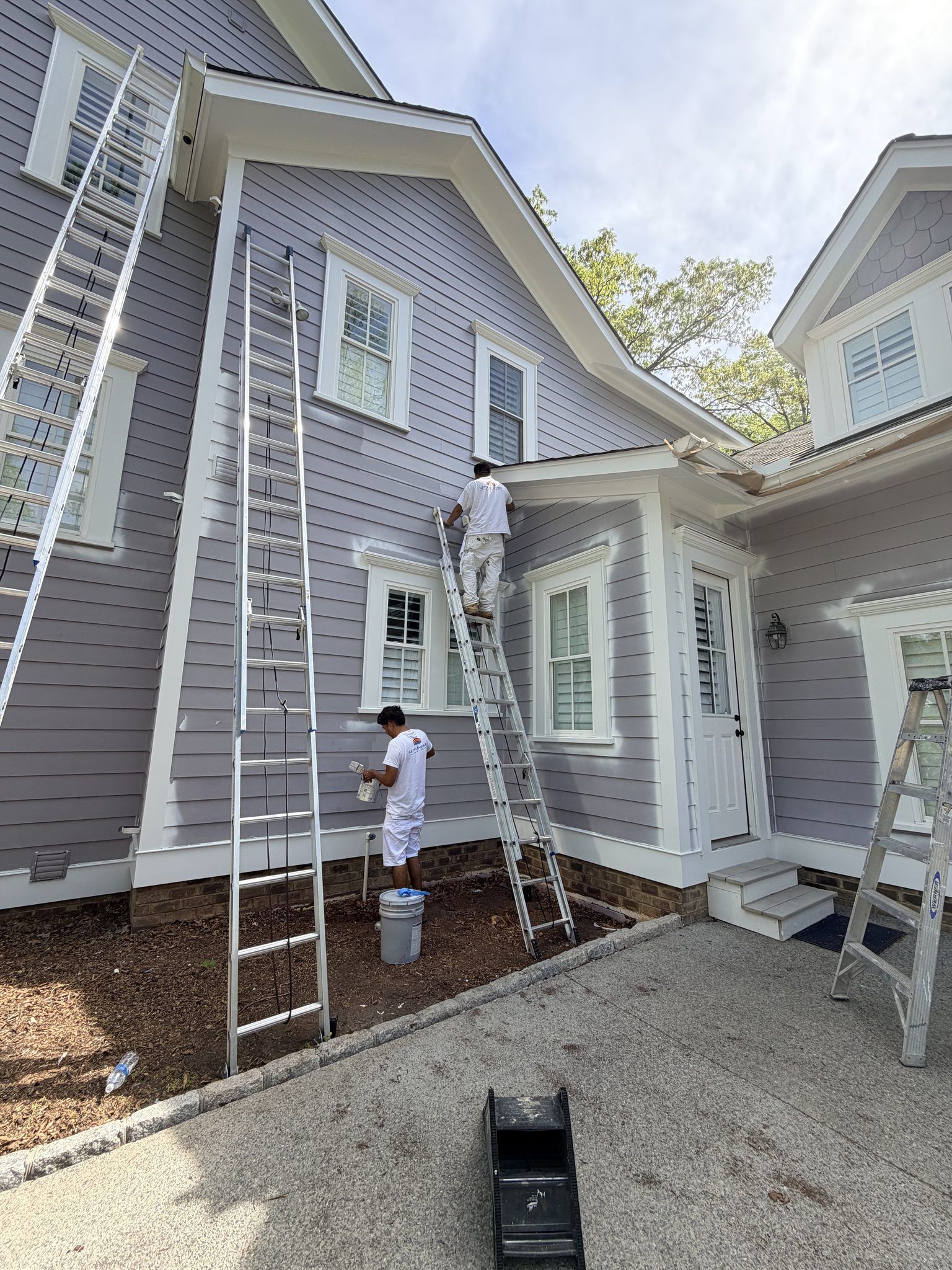 Painters On Ladders Painting A Lavender Siding Home