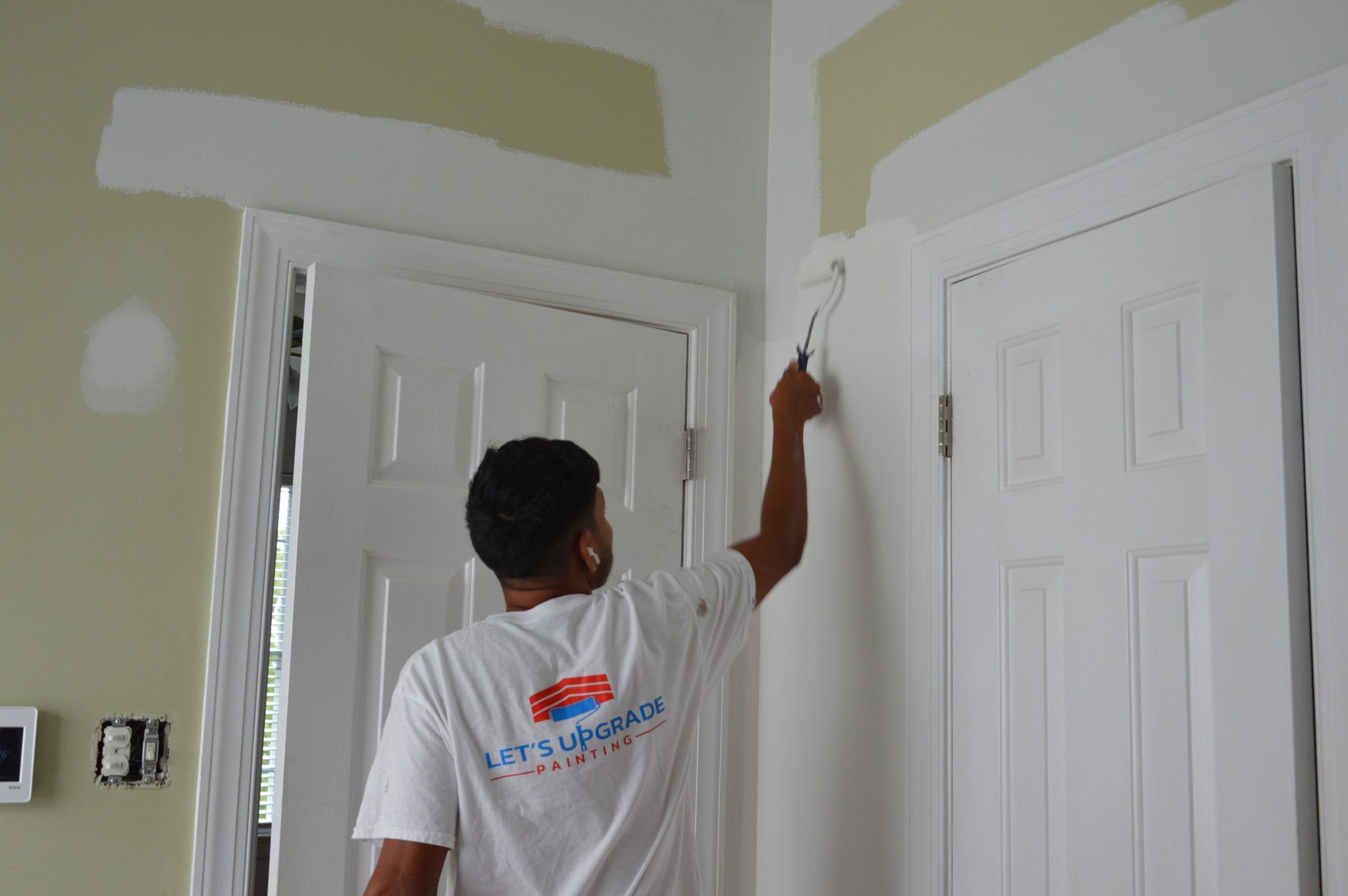 Painter Cutting In White Paint Around Interior Doors