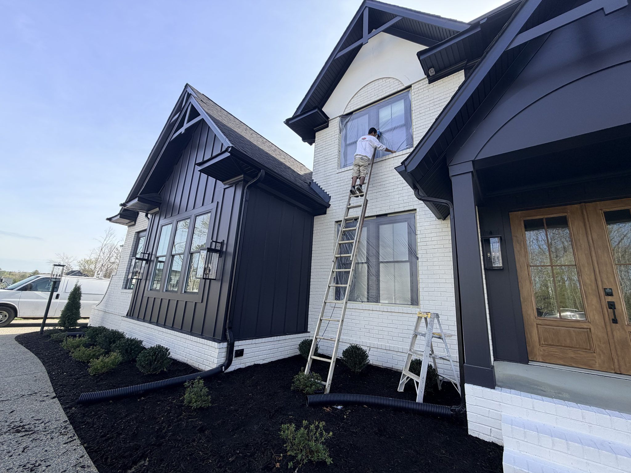 Painters On Ladders Painting A White And Black Modern Farmhouse