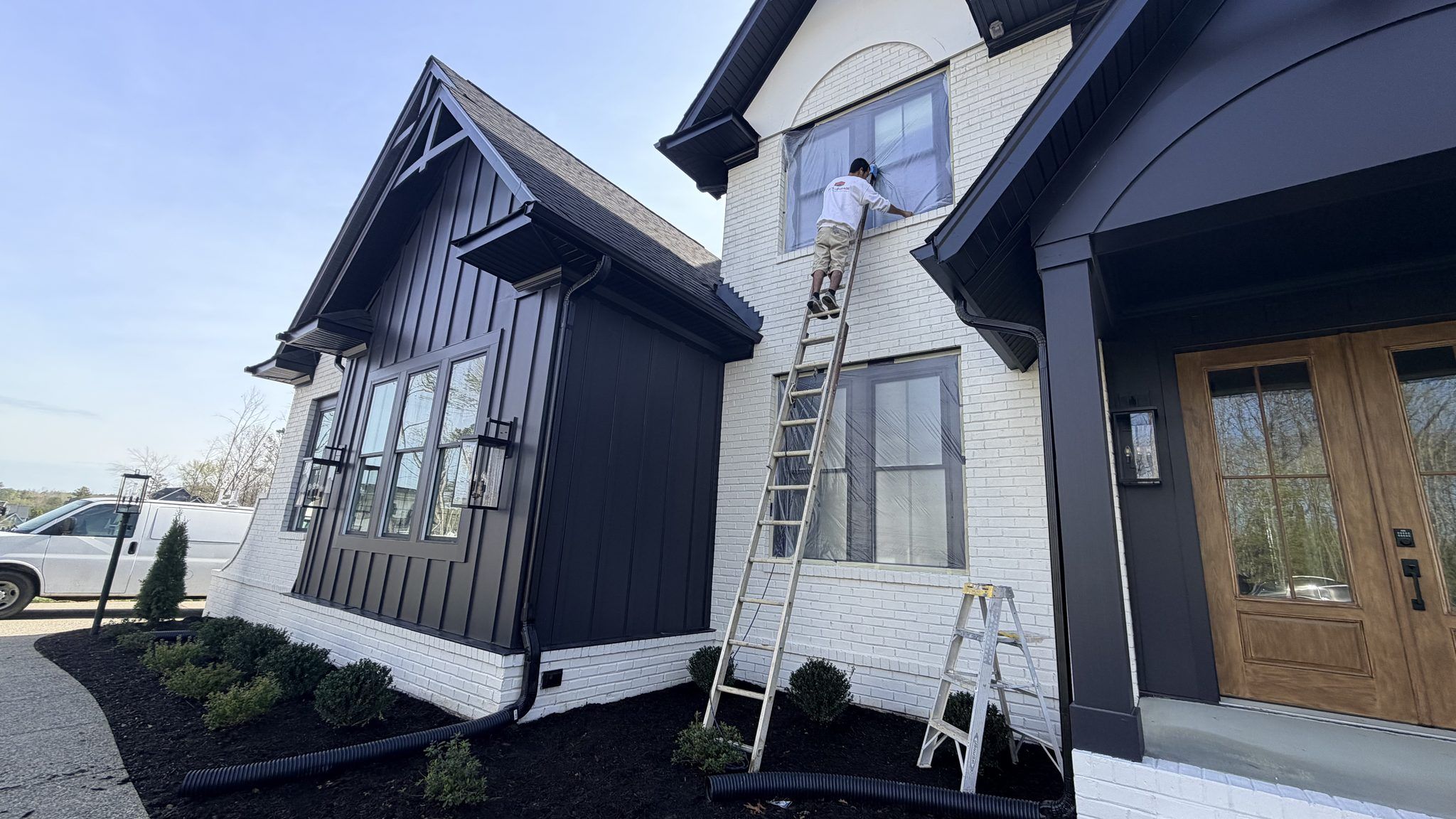 Painters On Ladders Painting A White And Black Modern Farmhouse