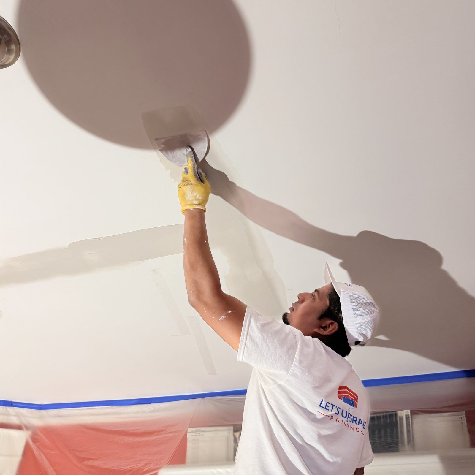 Painter Patching Drywall On A Ceiling