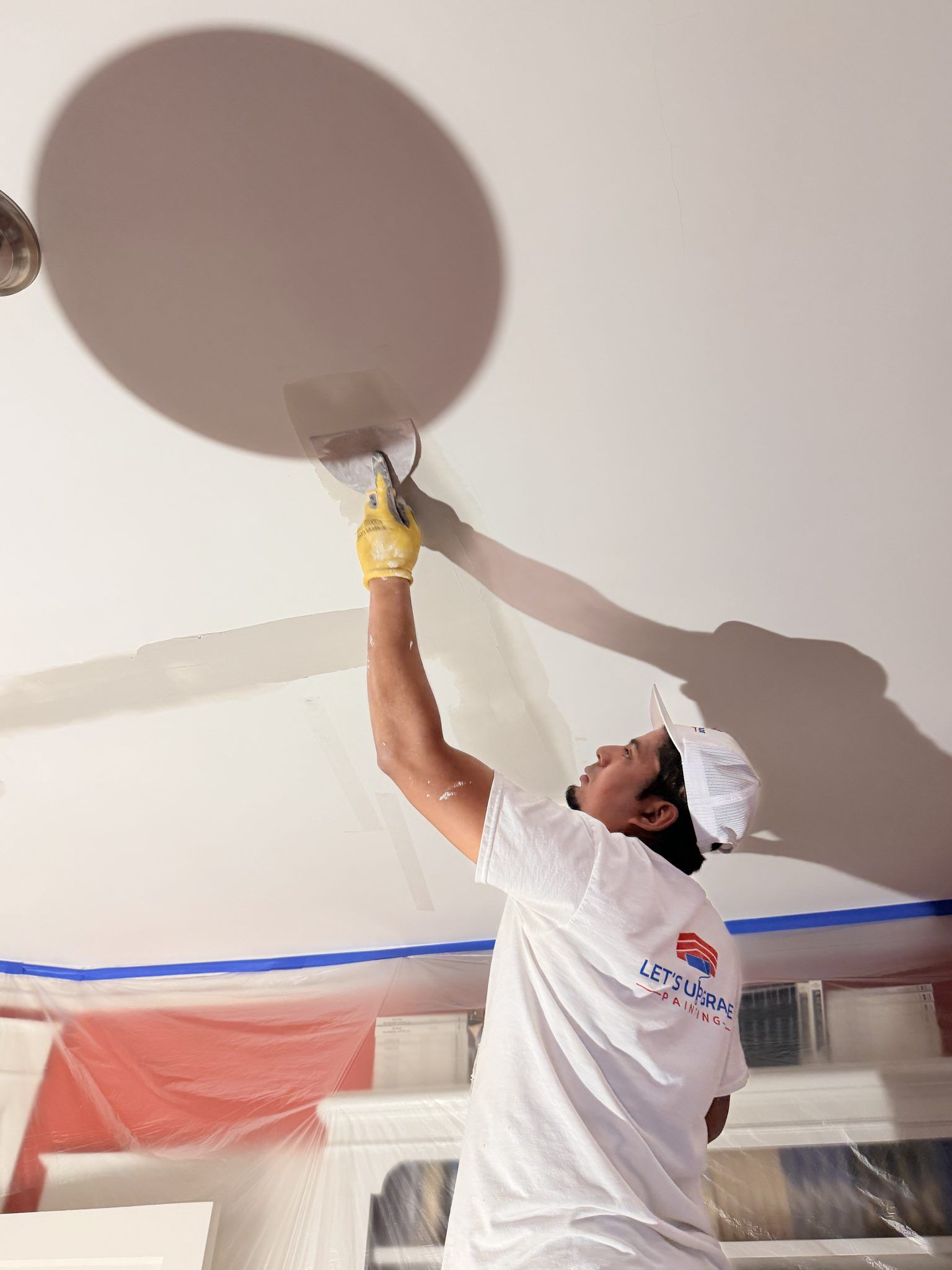 Painter Patching Drywall On A Ceiling