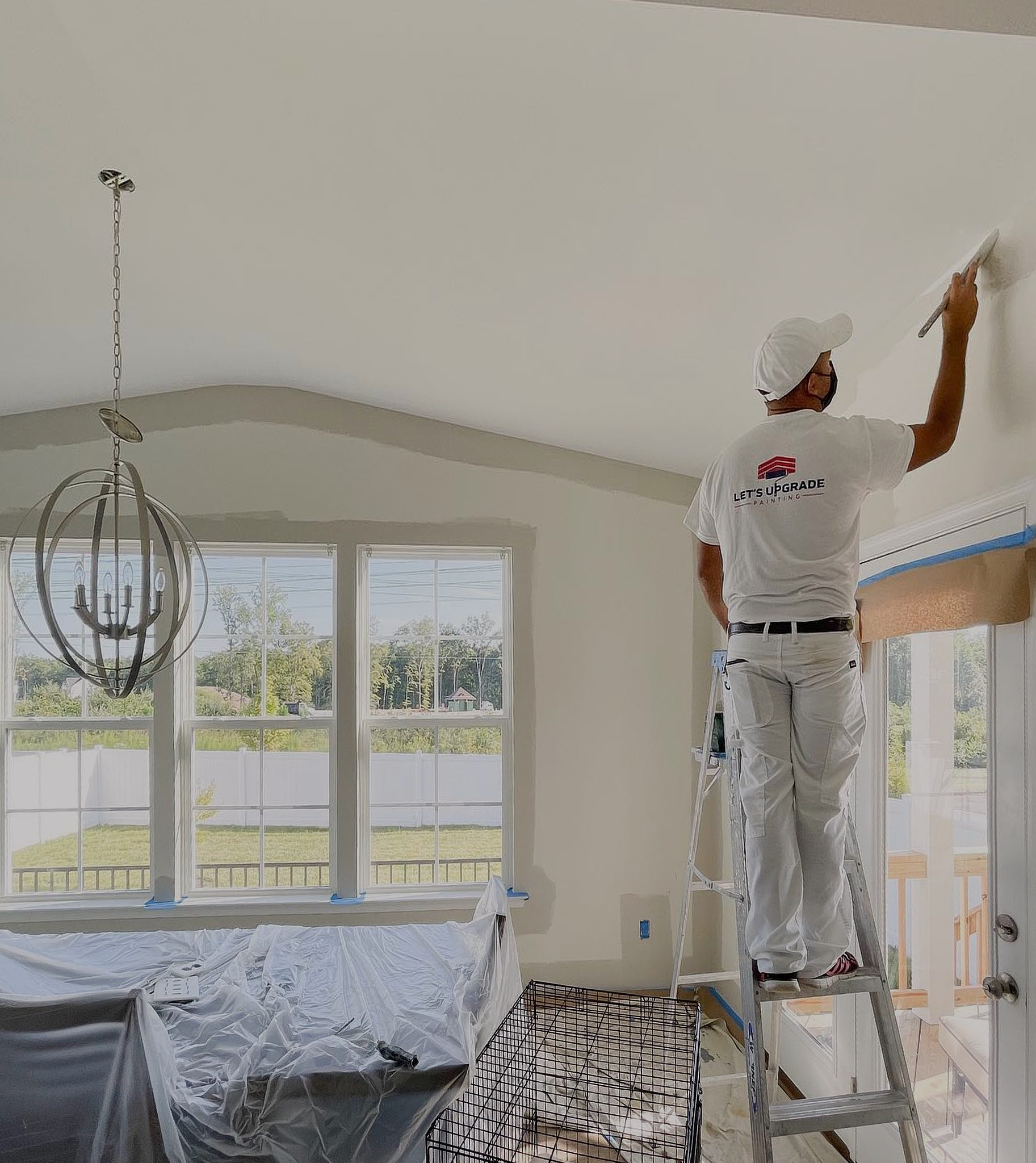 A Professional Painter From Let's Upgrade Painting Painting On A Wall Border Standing On A Wooden Stair