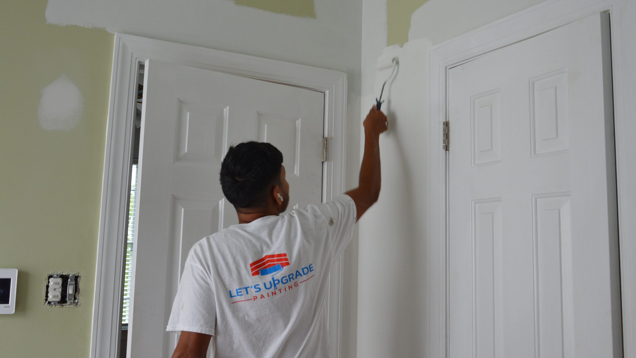 Painter Cutting In White Paint Around Interior Doors