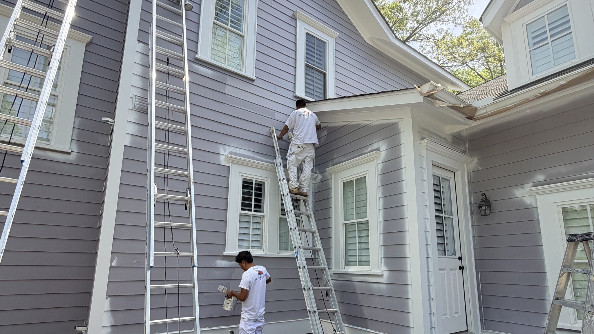 Painters On Ladders Painting A Lavender Siding Home