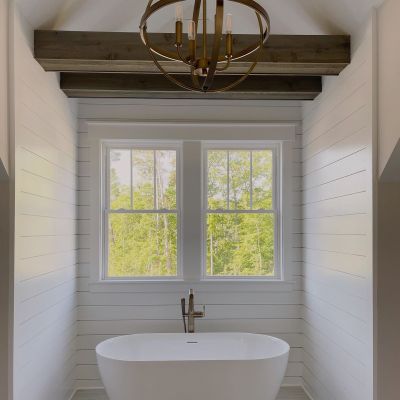 Beautifully Painted Bathroom In White Color With A White Bathtub And A Slider Window In The Background