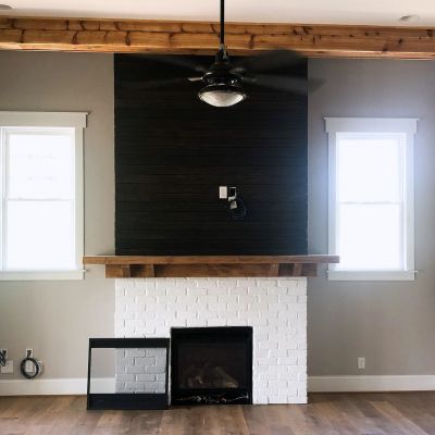 A Front View Of A Feature Wall Corner In A House Painted In Black Color With A Fireplace Underneath It