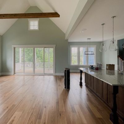 A Main Hall Area Of A House With Clean Brown Marble Flooring, Light Green Painted Walls, And White Painted Ceiling
