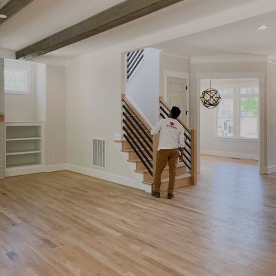 Men With A Branded T-Shirt Lets Upgrade Painting Facing Away From The Camera Is Reviewing A Newly Furnished House