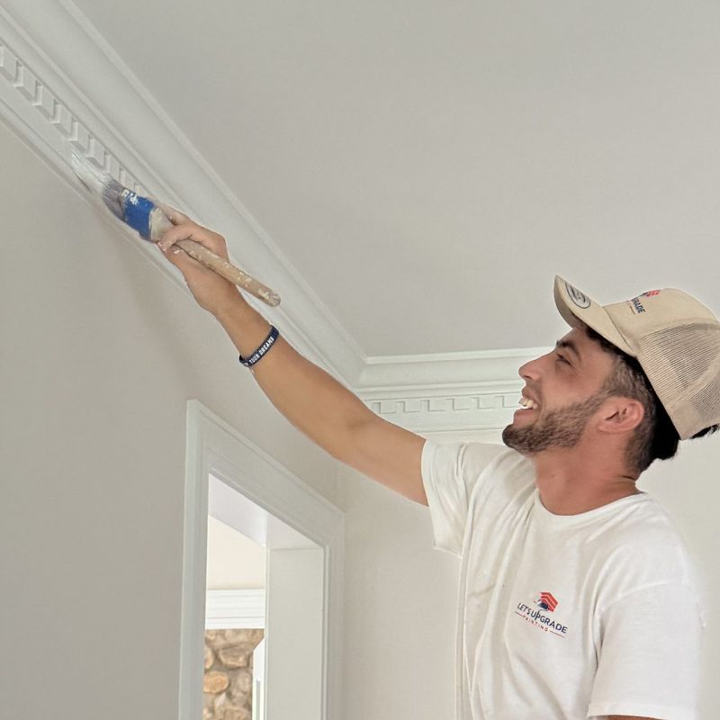 Painter On A Ladder Painting Crown Molding