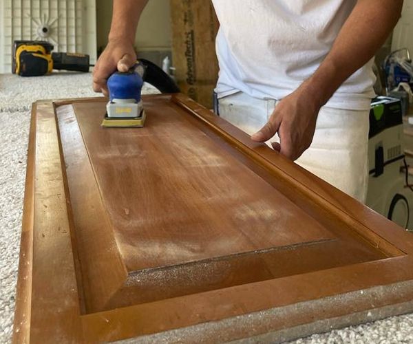 Preparation By Employee With Sander For Kitchen Cabinet Door