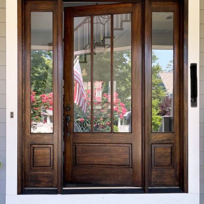 A Wide Main Wooden Door Of A House Polished Very Cleanly With A Dark Brown Color