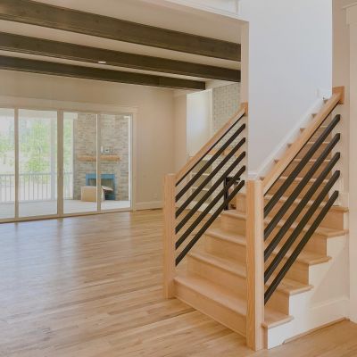 A Neat View Of The Wooden Stair Railing Painted In A Beautiful Wooden Color, Featuring Shiny Black Lower Bars