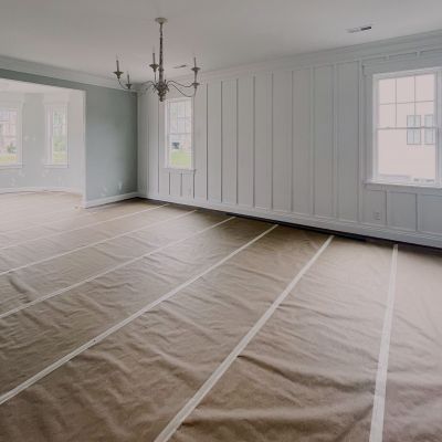 A Newly Painted Hall Inside A House With A Drop Cloth Laid Down All Over The Floor