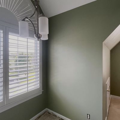 Corner Inside A Room With Some White Grill Decoration, And Forest Green Painted Walls
