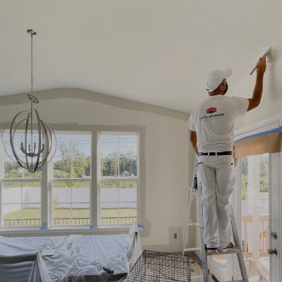 A Professional Painter From Lets Upgrade Painting Painting On A Wall Border Standing On A Wooden Stair