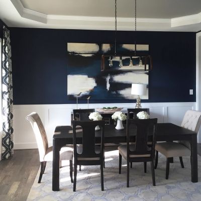 Dining Table In A Room With A Vibrant Navy-Colored Front Wall Creating A Beautiful And Striking Contrast